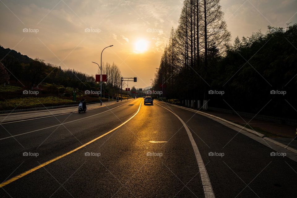 A beautiful view of sunset along the road .