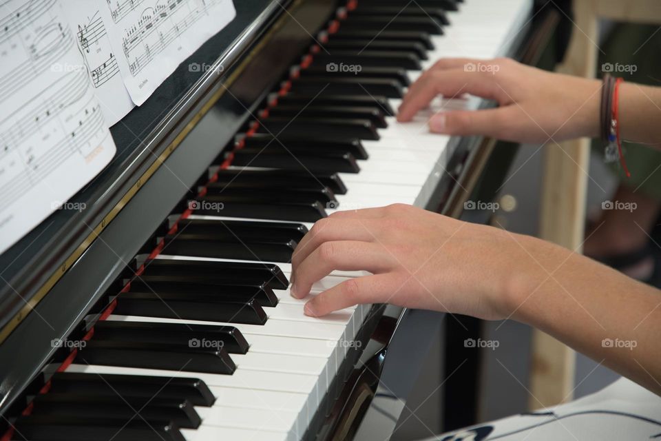 teenage girl playing the piano in the concert hall, hobby, playing music on the instrument

