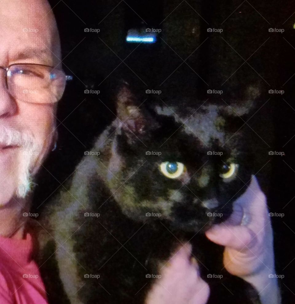 Man holding black cat.