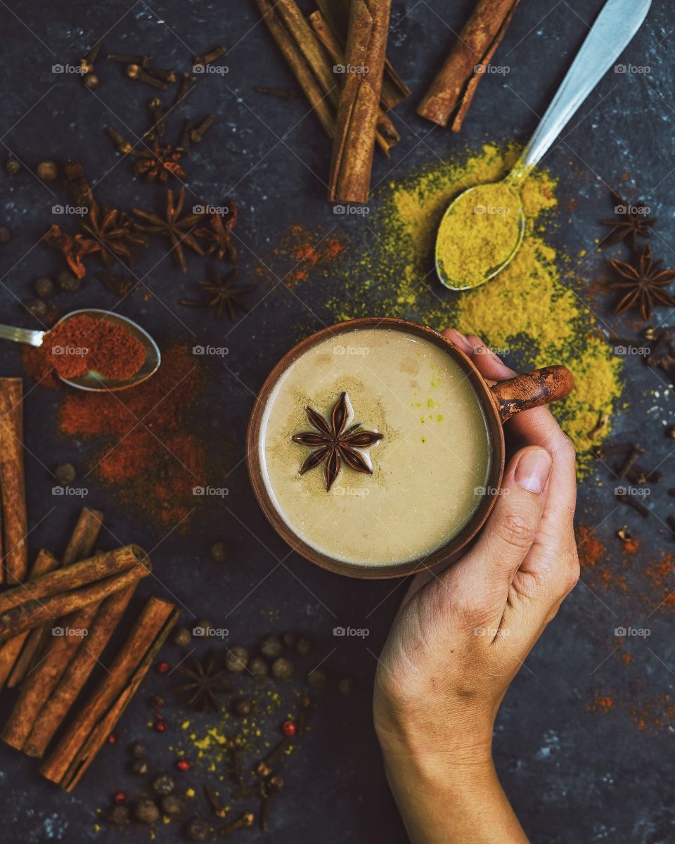 girl's hand holding cup of spicy masala chai