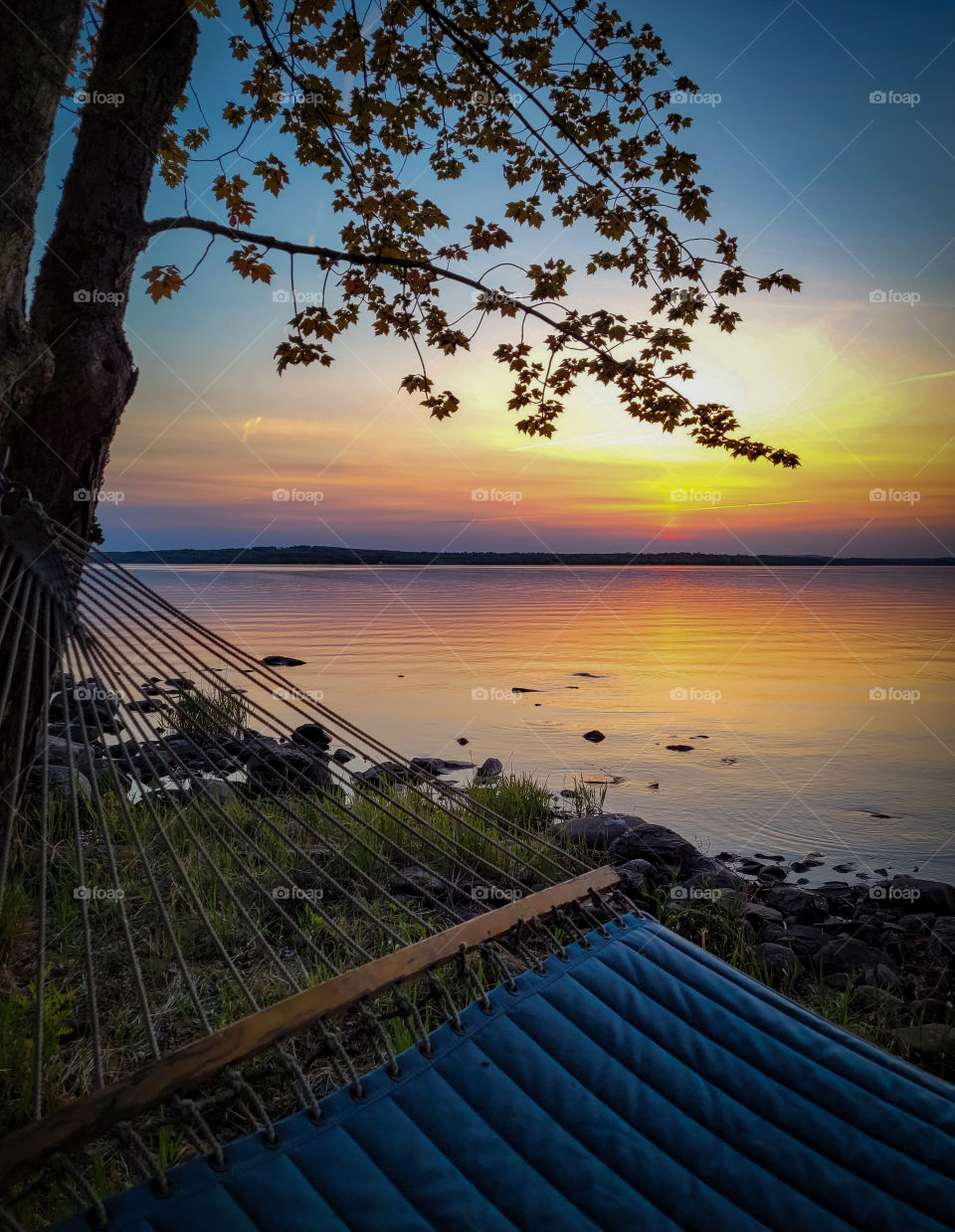 Sunset over the lake from a blue hammock on the shore