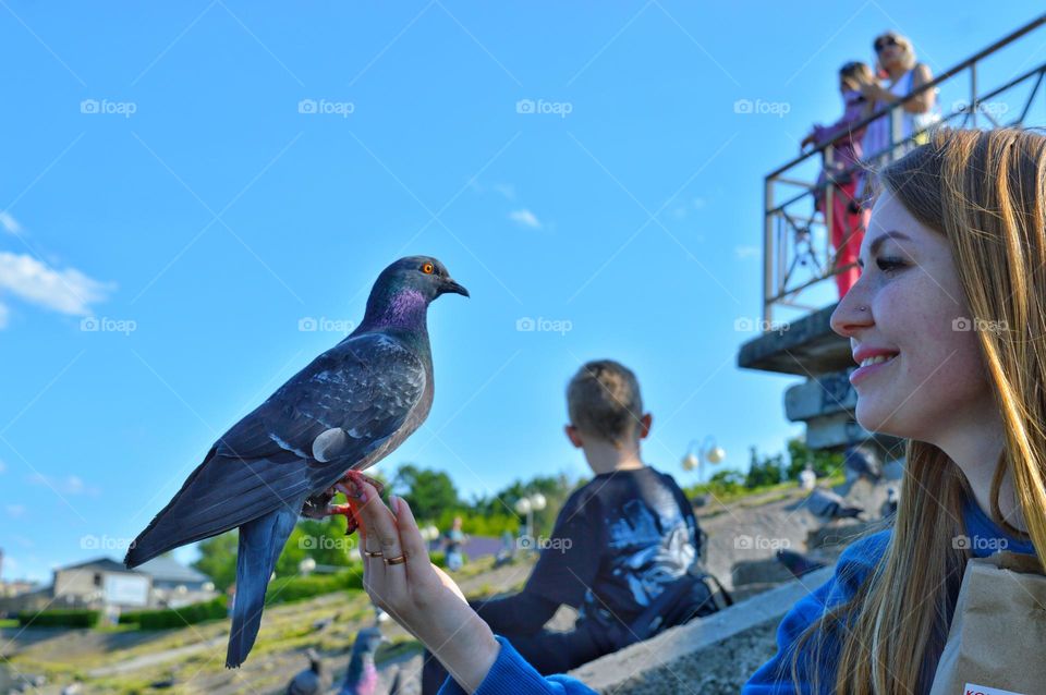 a dove sits on the girl’s hand and this delights her