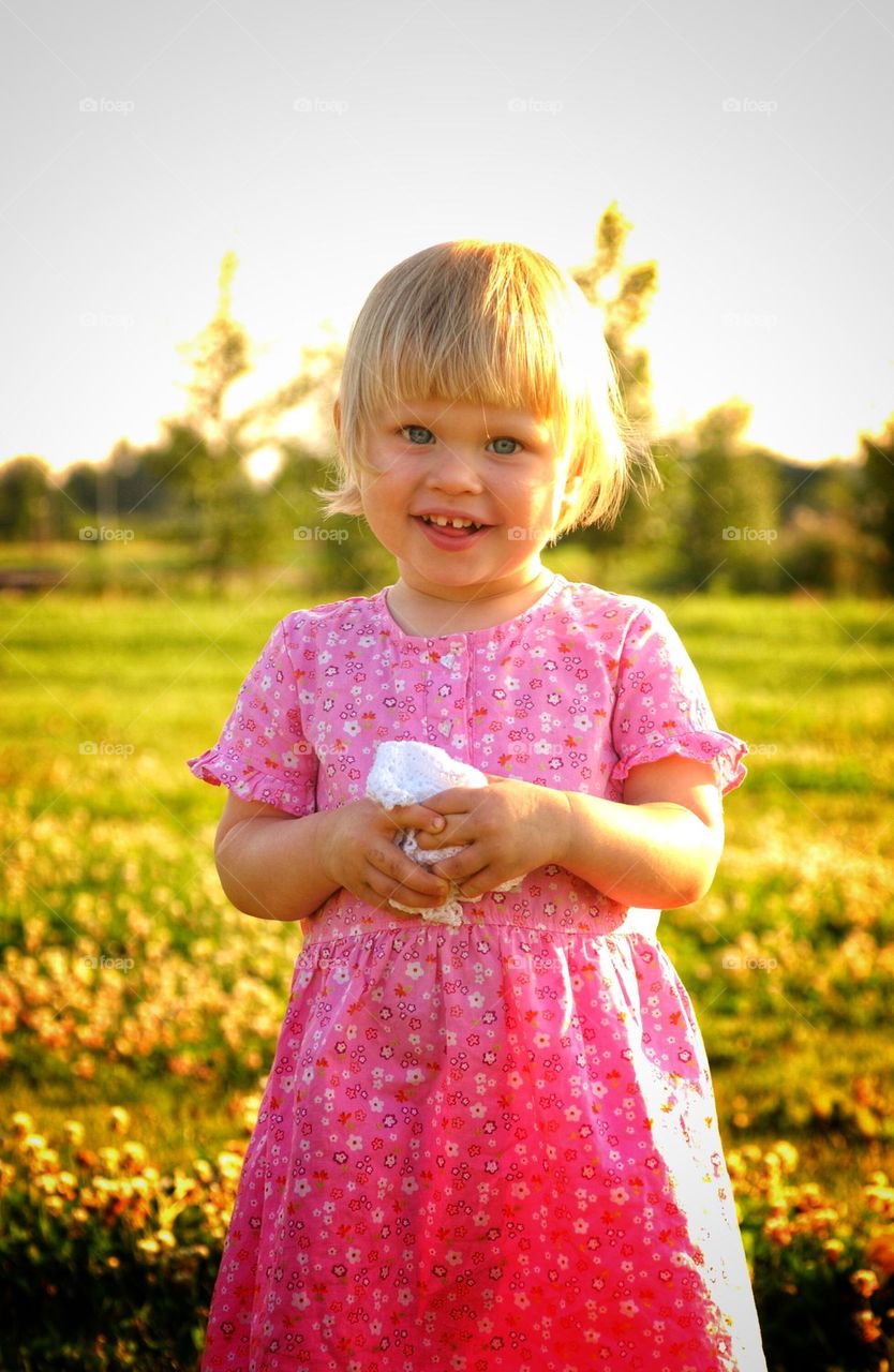 Happy littlle girl in bright summmer light.