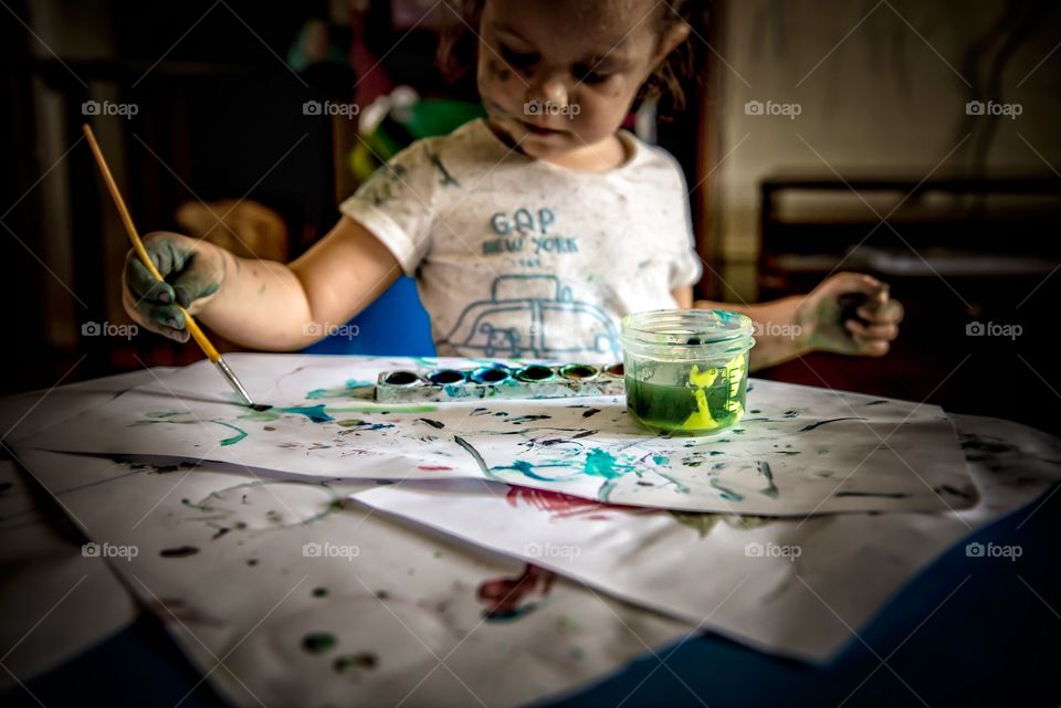 Boy painting on paper with water color