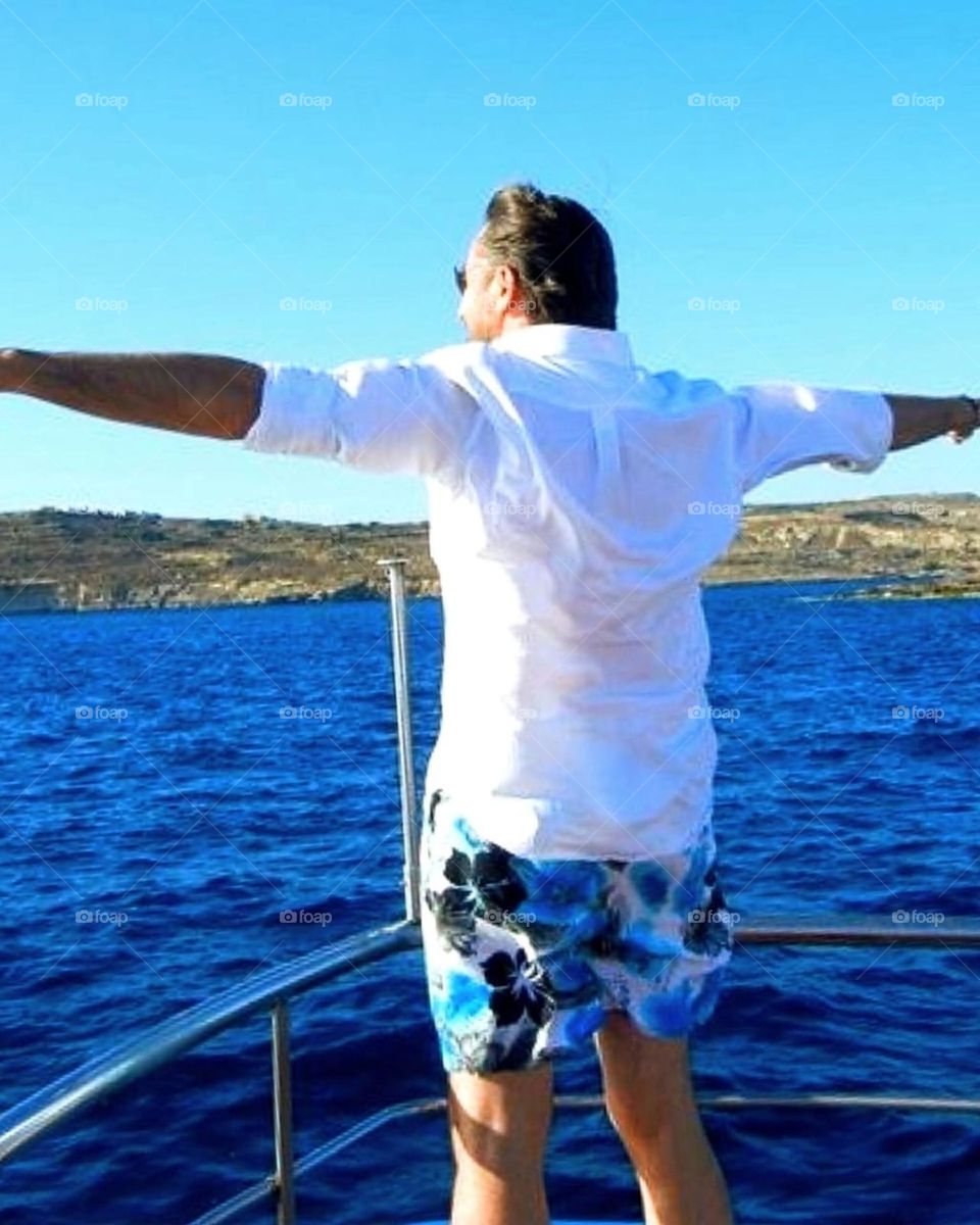 Sea. Dark blue sea. The bow of the yacht, on which stands a man with open arms. To meet the wind, the sun