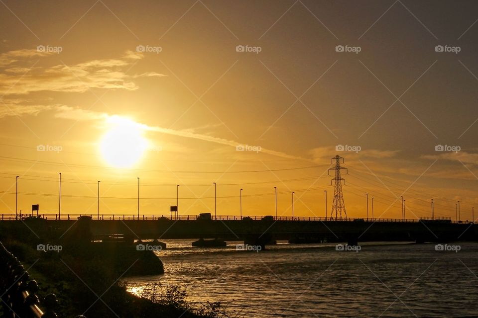 Silhouette of bridge over the river at sunset