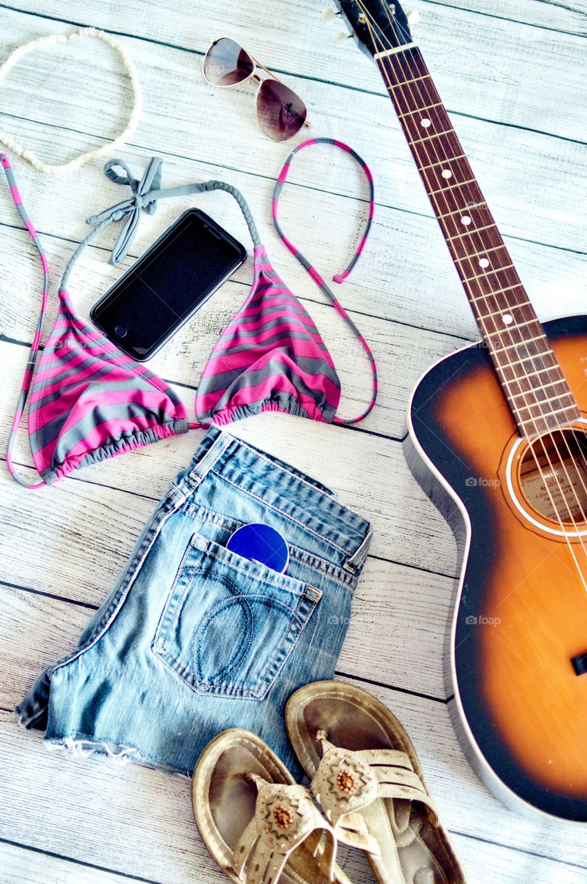 Summer clothing flat lay with an acoustic guitar 