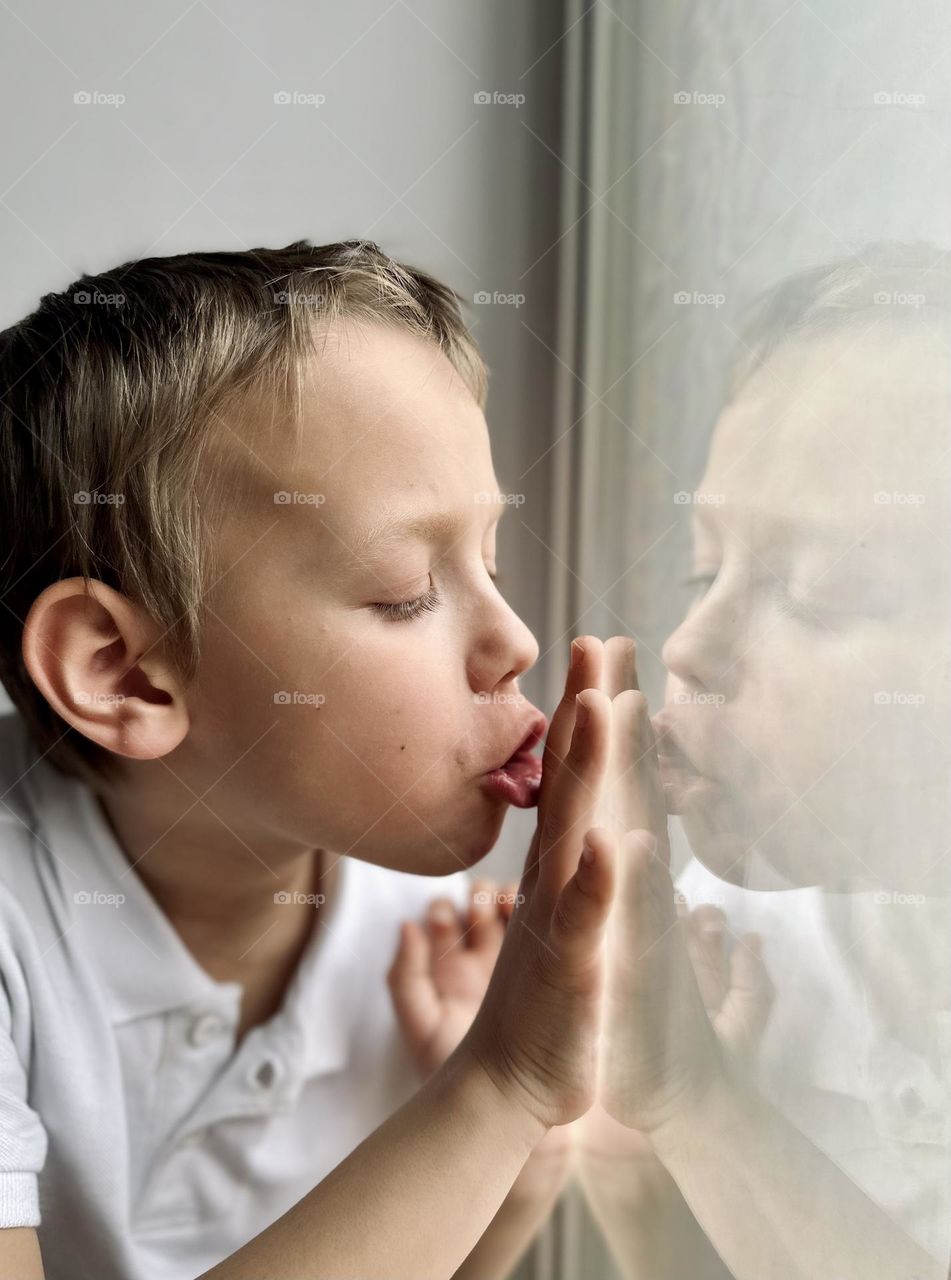Boy blowing on the window
