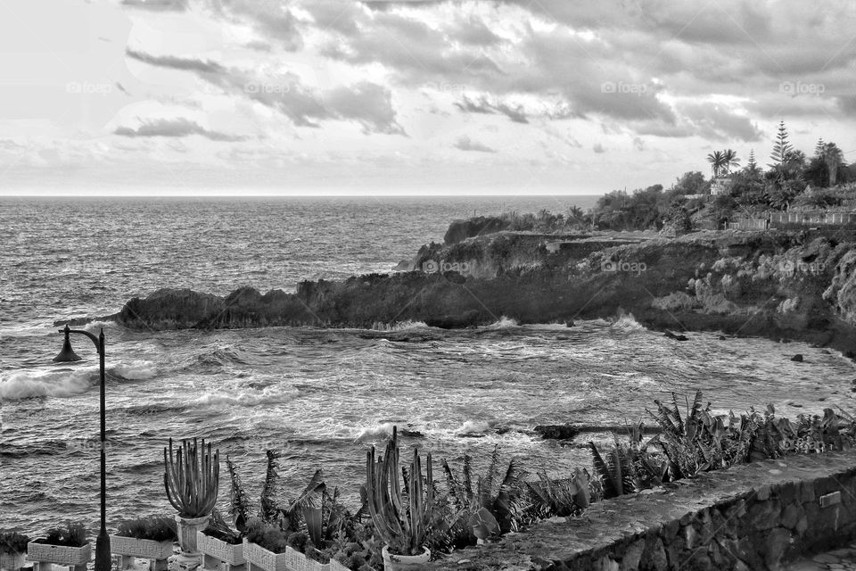 Black and white photo of the stormy Atlantic Ocean with cliffs
