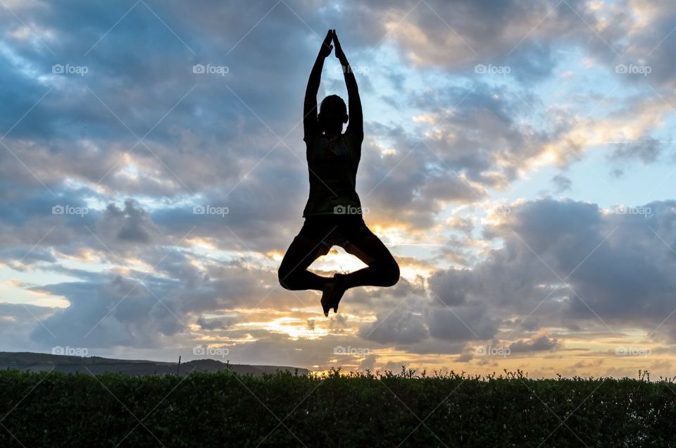A girl jumping in a yoga position 