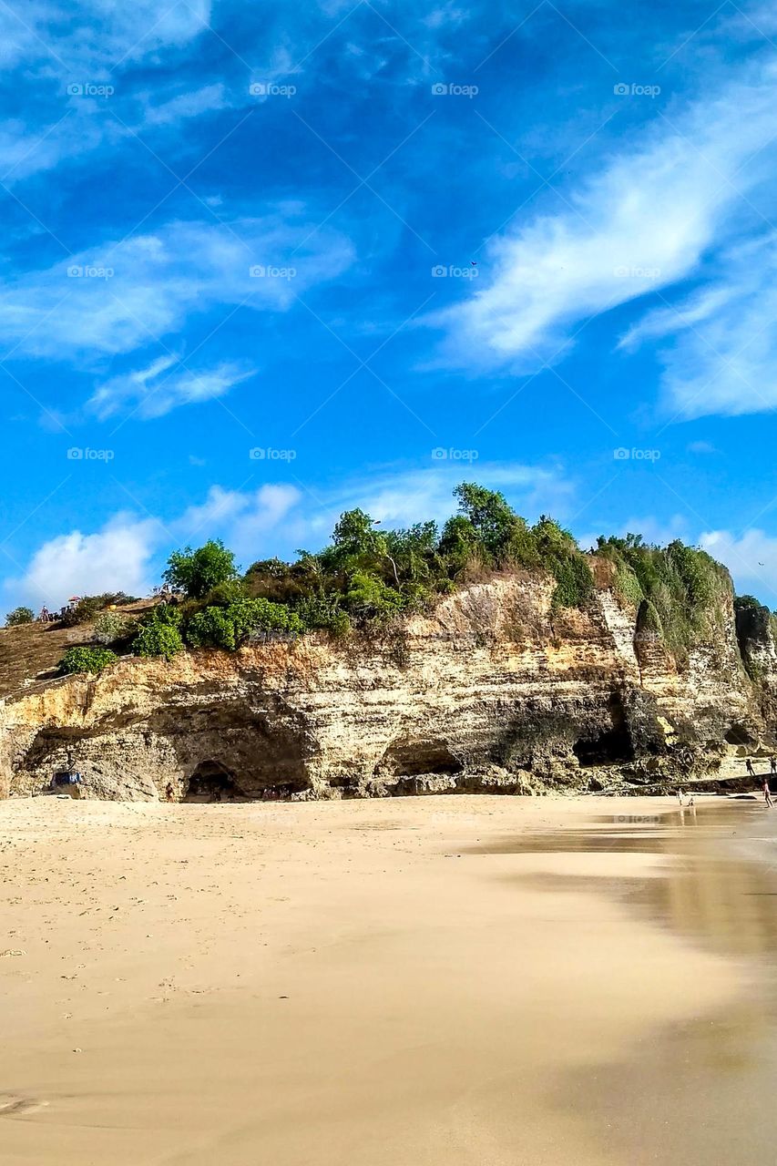 View of the cliffs on the edge of the white sand beach in eye level view