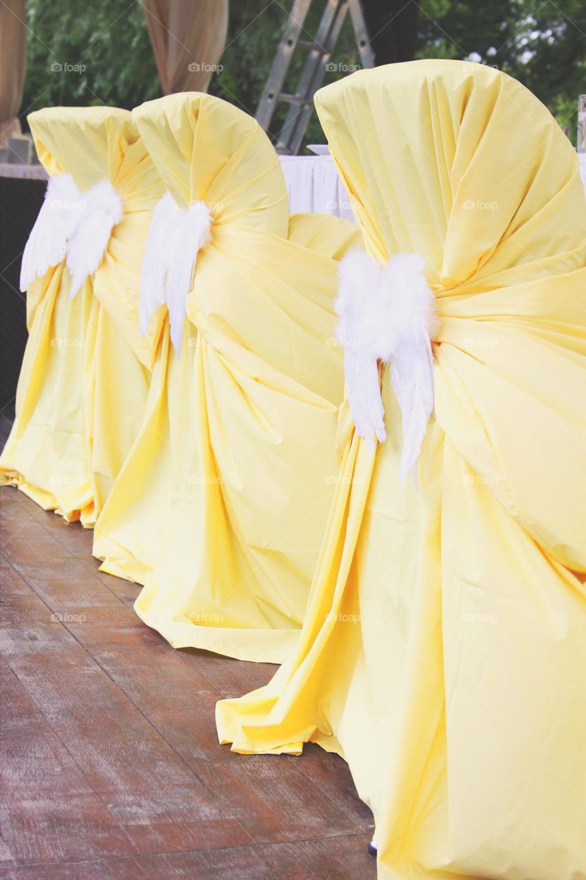 Yellow decoration. Yellow chairs with angel wings