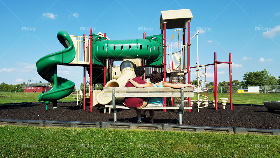 Playground. parents supervise toddlers on playground