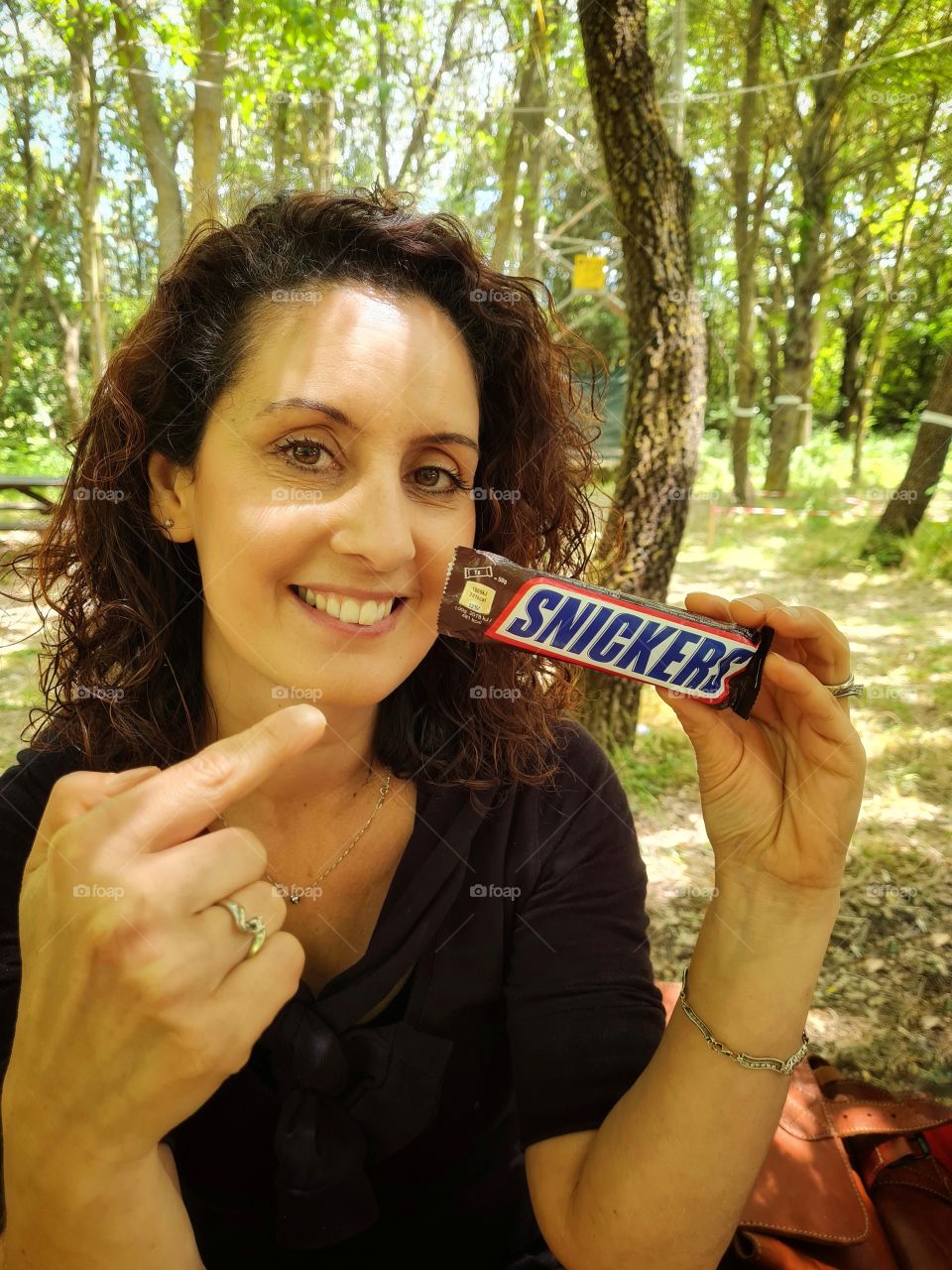 smiling and satisfied woman shows her snickers