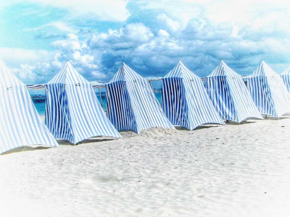 Hi Key Brach Tents. A row of blue and white beach tents on a white sand beach.