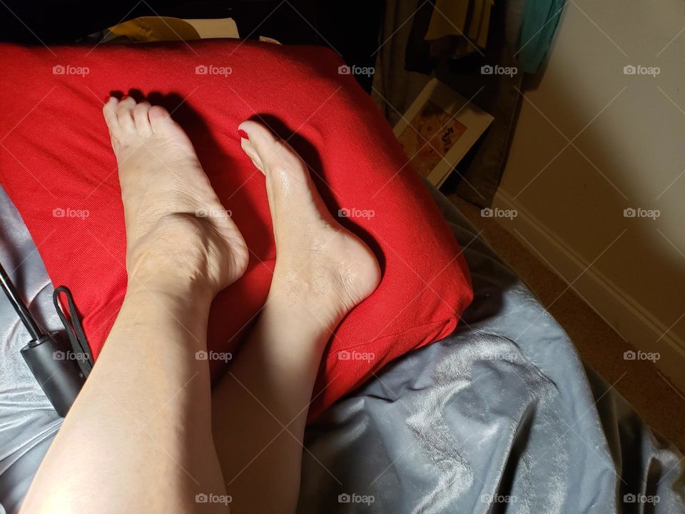 elegantes pies recostados en almohadón rojo la belleza única femenina representada en esta bella imagen,para los amantes de pies bonitos esta sería una bella imagen que no encontrarás en otro lugar