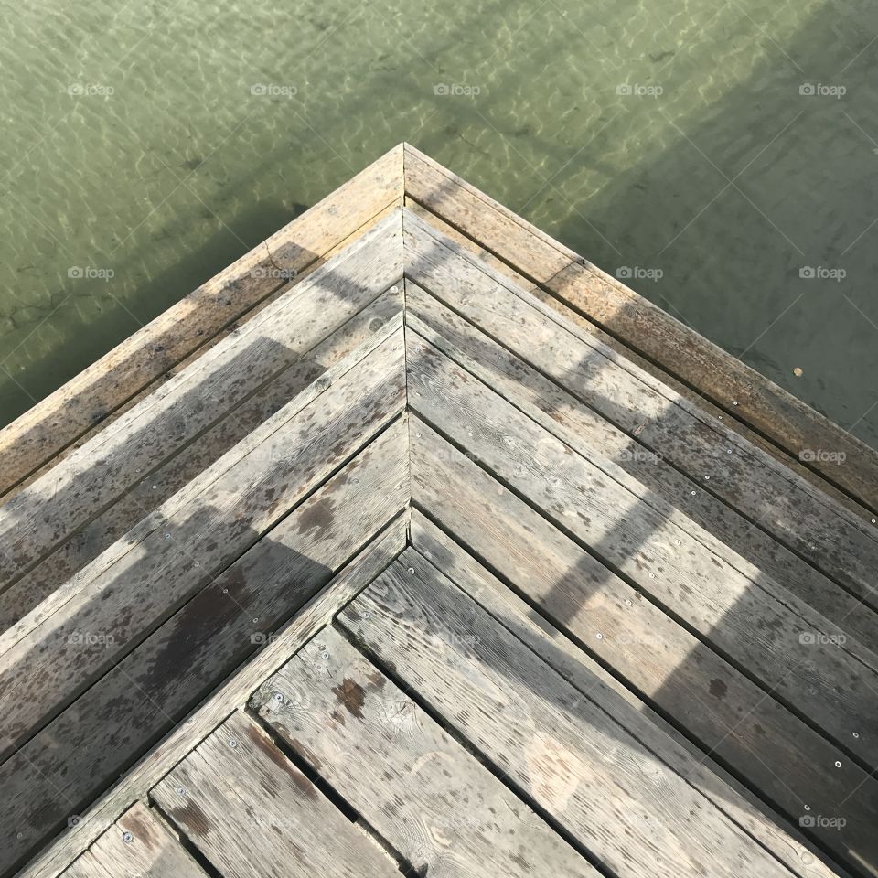 Seen from above: Three wooden steps going down into the sea