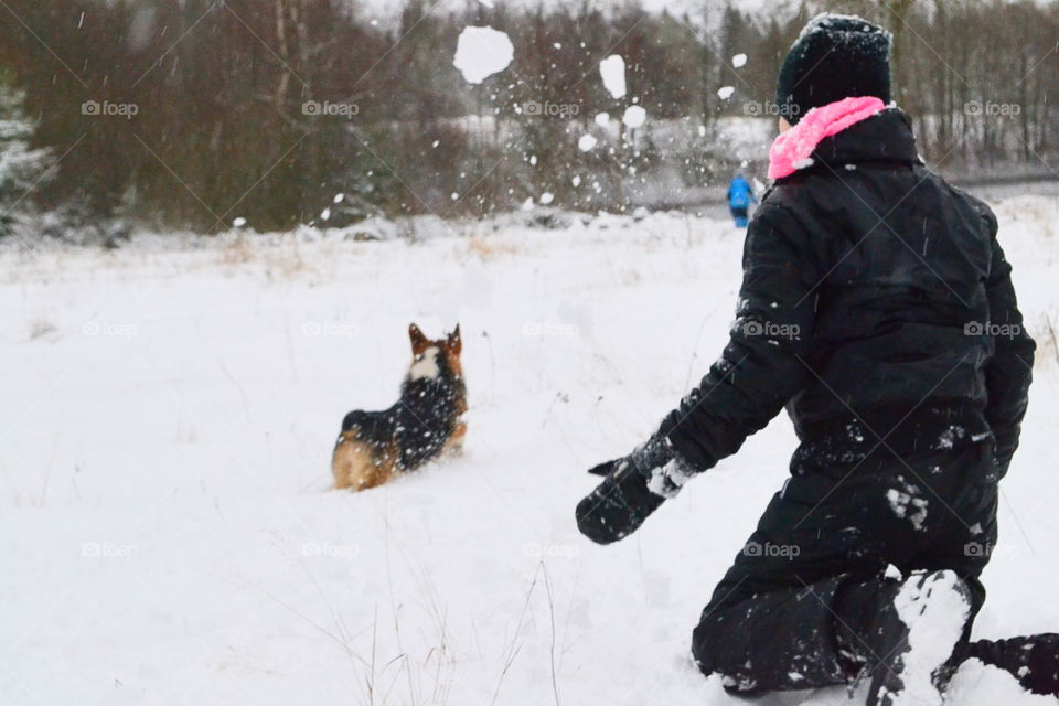 Girl playing with a dog in the snow