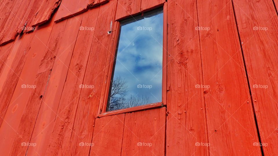 Red barn with window reflecting the sky