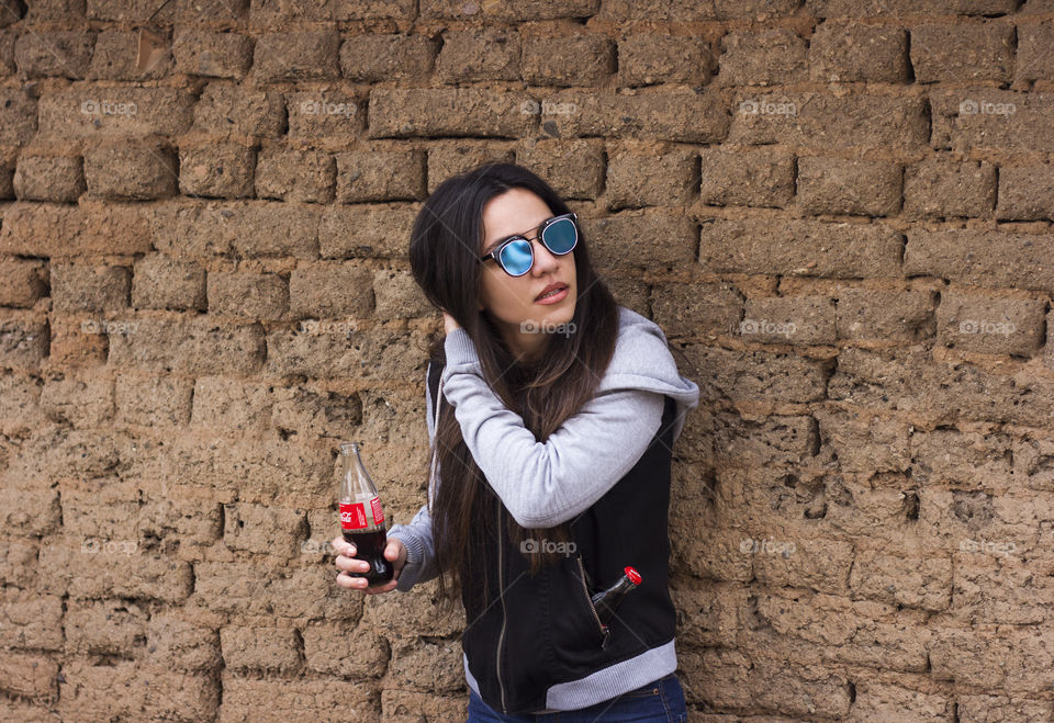 Young woman holds Coca-Cola bottle