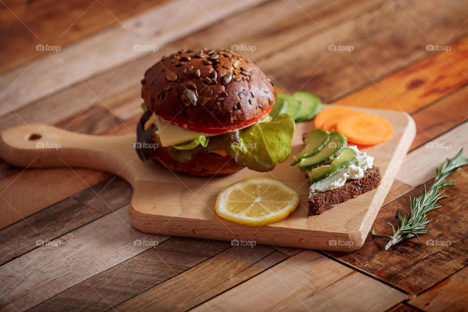 Dark burger with grain bread, cream cheese and avocado