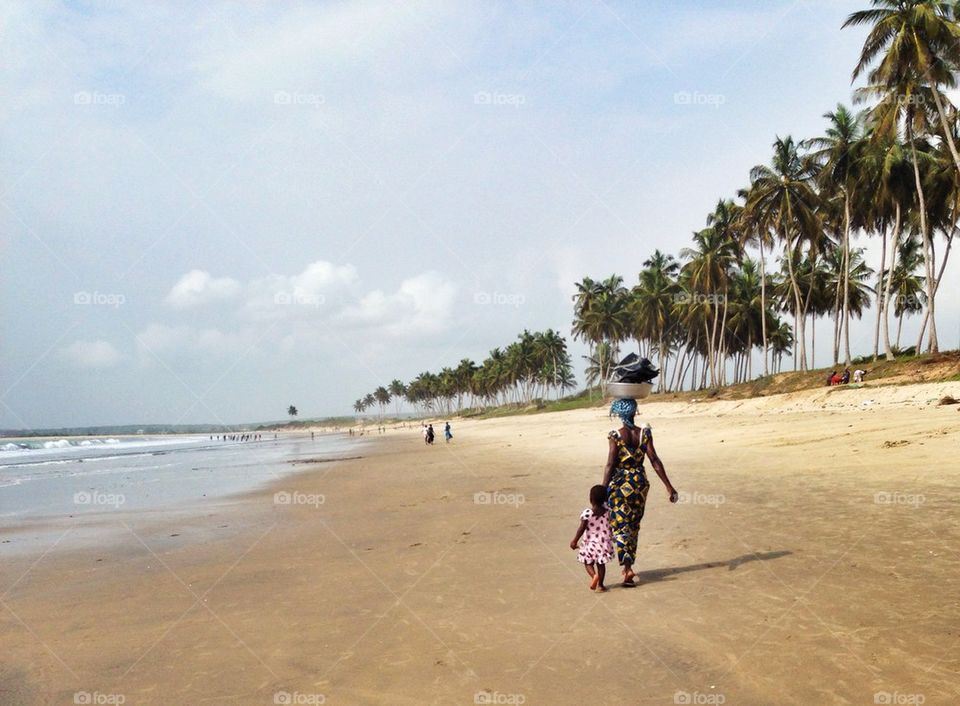 African Woman and child walking on the beach