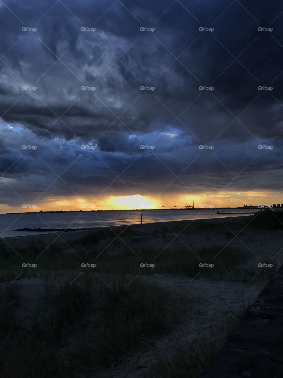 Dark cloudy sky during sunset and storm, on the beach 