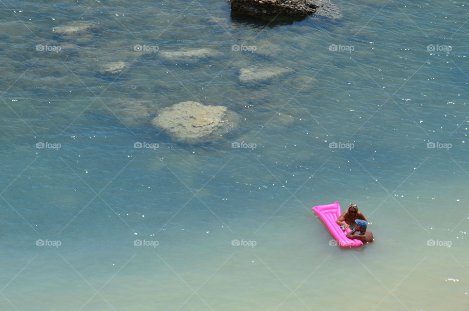 Pink mattress in the blue sea