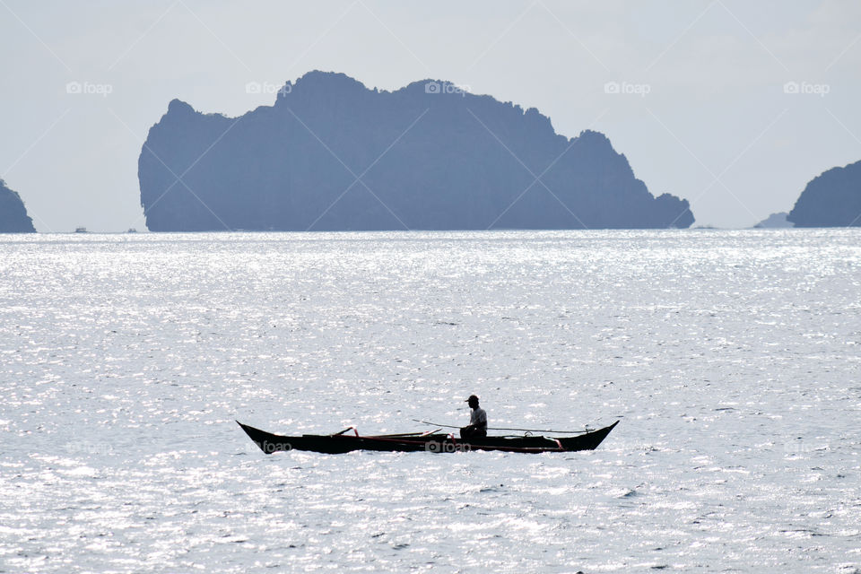 Silhouette of a man riding on a boat