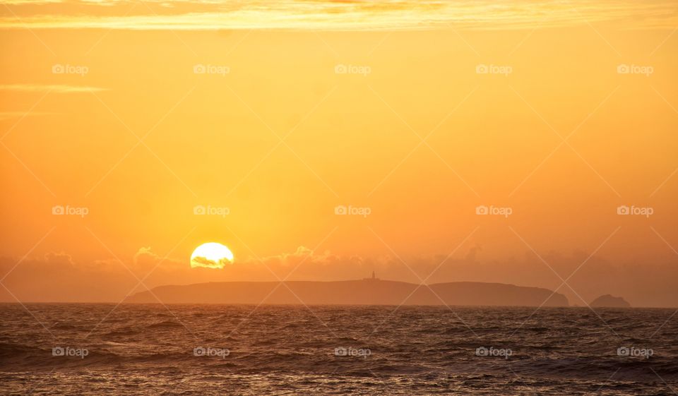sunset by an island in the ocean