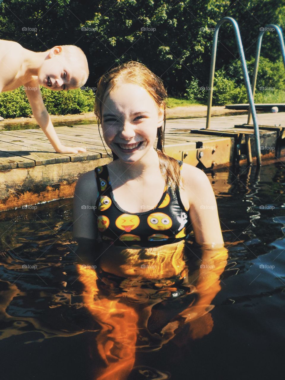 Happy girl with her brother in the background stealing the show