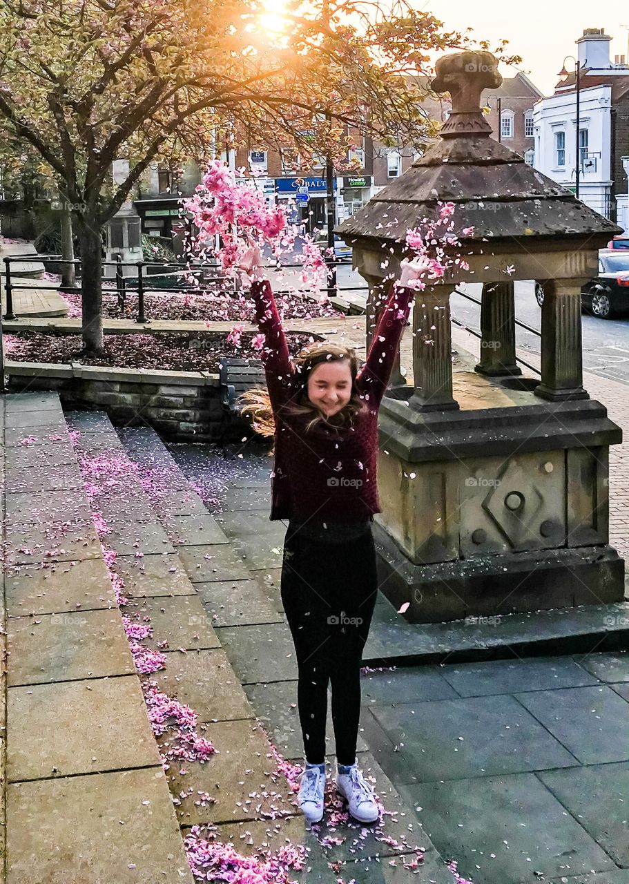Close-up of a girl throwing flowers petals