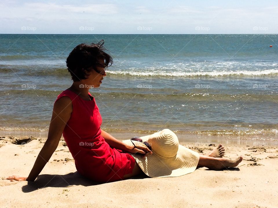 Lady in red dress on a beach