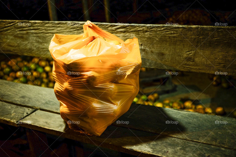 Bag full of oranges at a stall in the evening