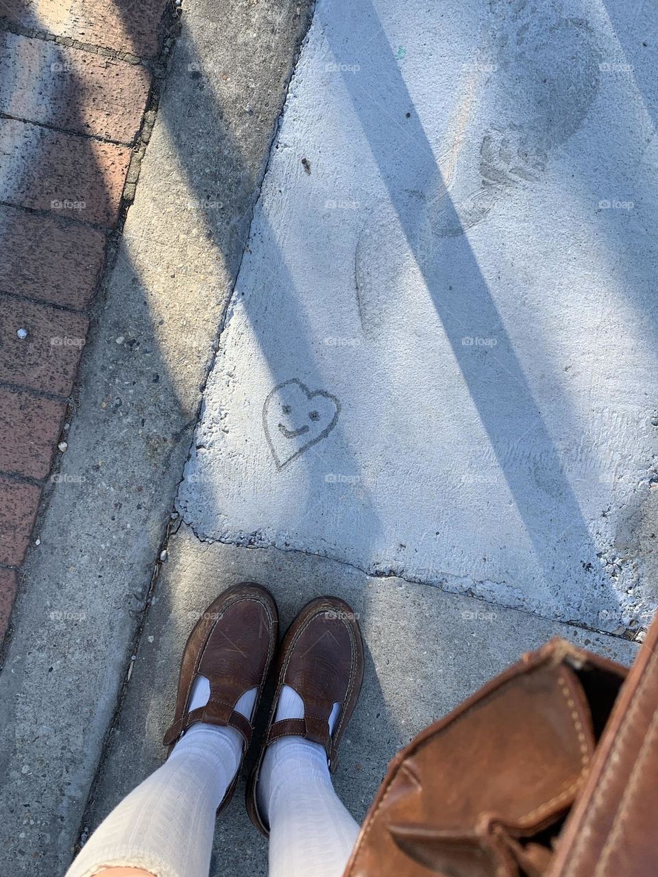 On a walk at an art fair and found the cutest little smiley face that was put into the concrete!