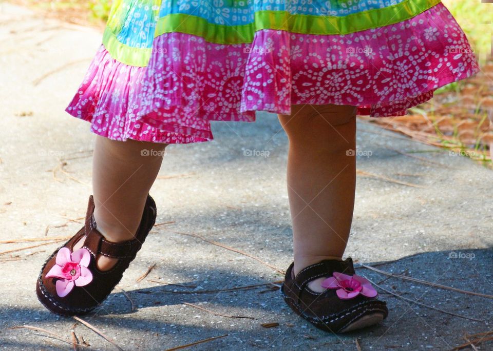 Sweet Feet. Little girl walking in colorful clothes 