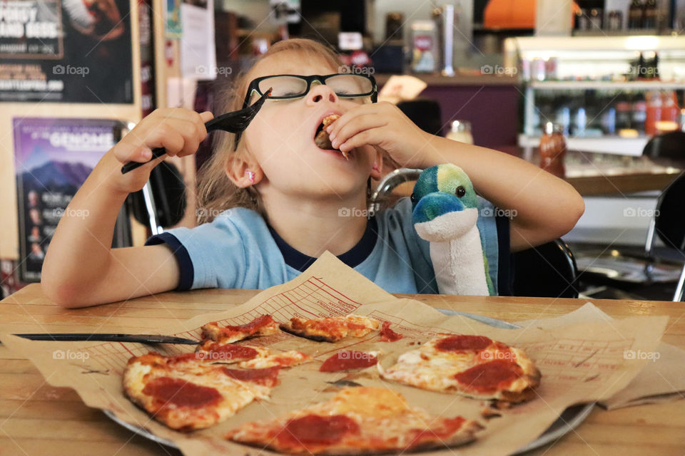 Child loves eating pizza