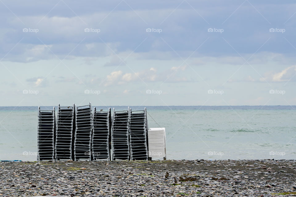 an empty pebble beach after the end of the tourist season, a lot of plastic loungers, Batumi, Georgia