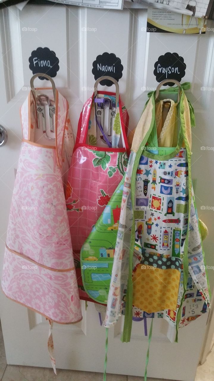 Row of Colorful Aprons Hanging on Hooks