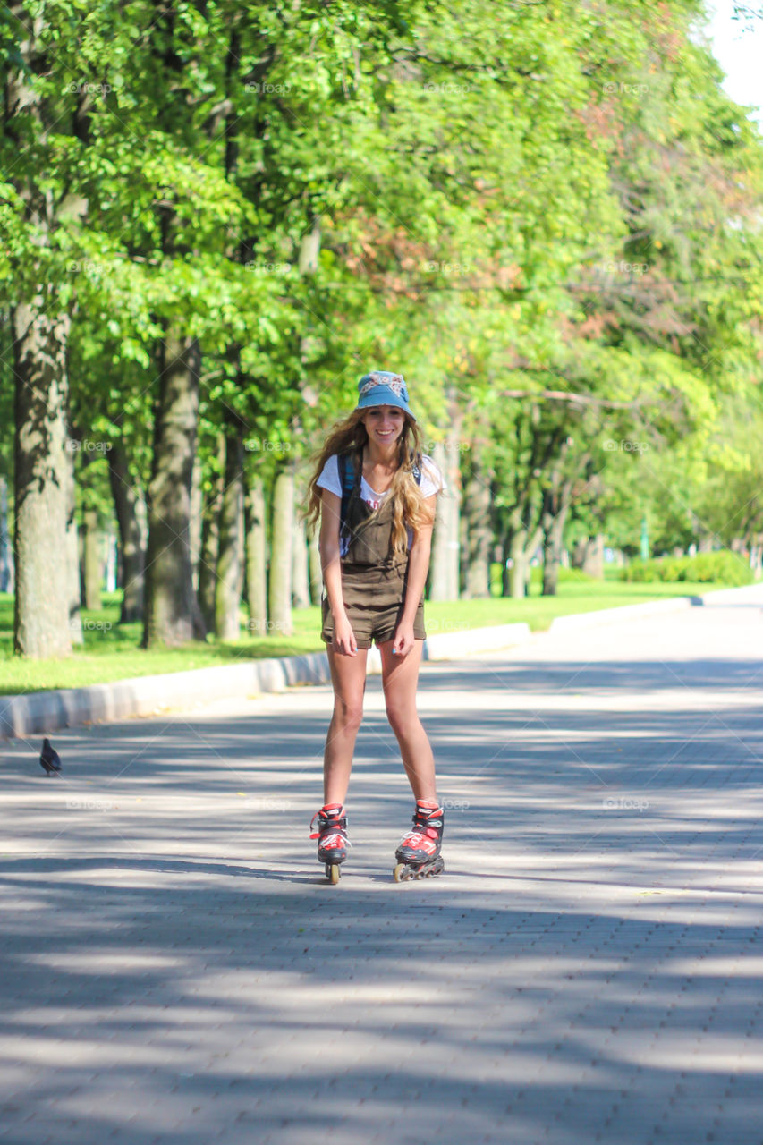 Happy young woman roller-skating in park