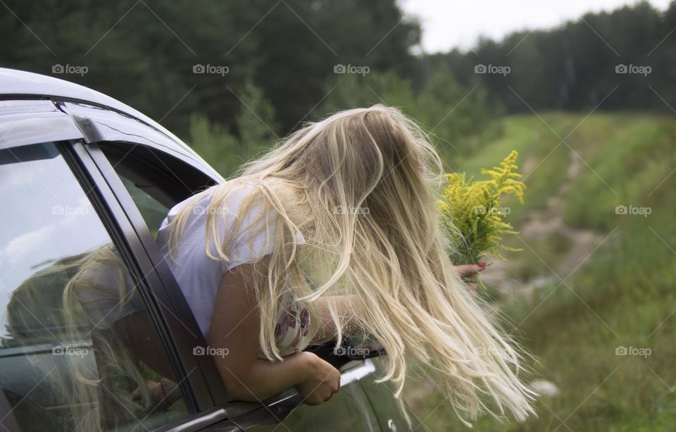 A girl rides in a car on the road