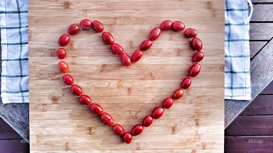 Heart shape of tomatoes on wood