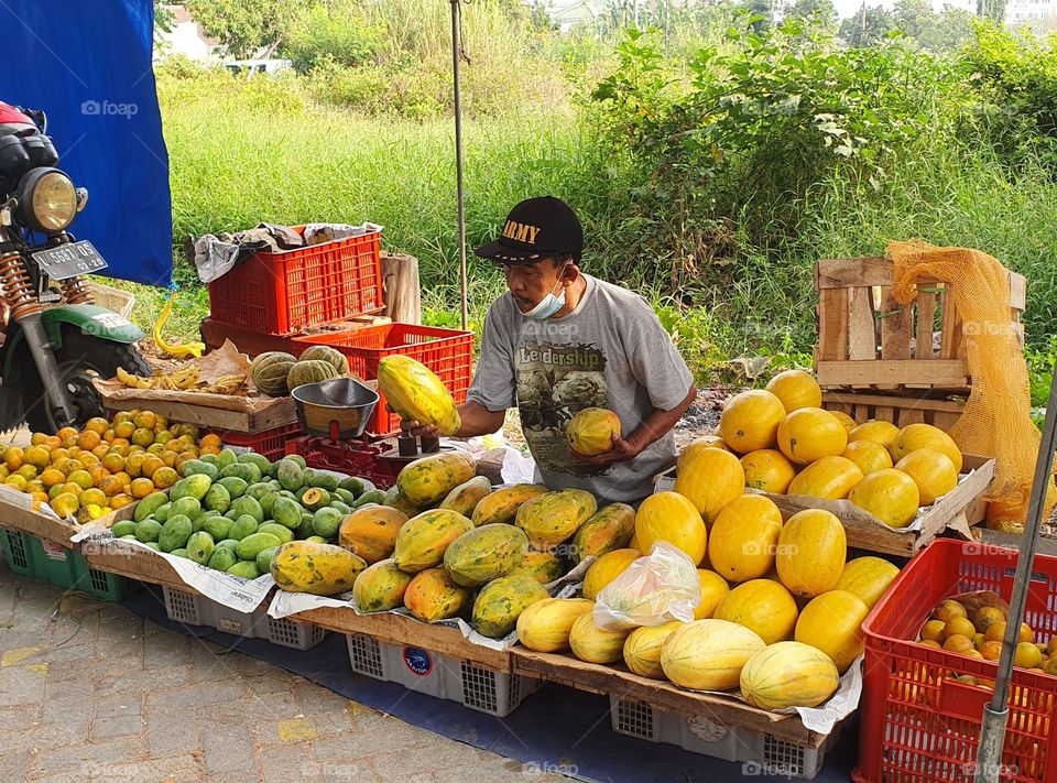 a fruit seller is busy checking the quality of his merchandise