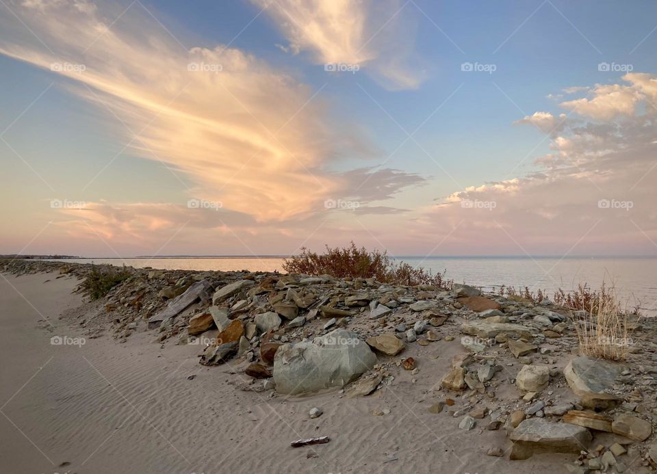 Lake Eerie Beach pink and purple Sunset, small hills of sand and rocks on Cedar Point Beach
