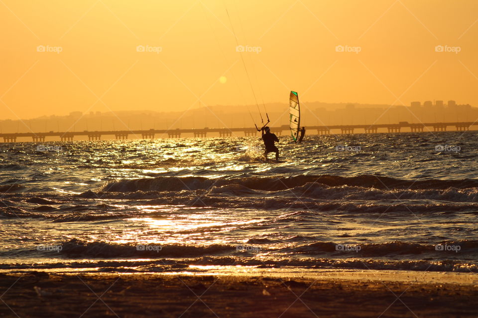 Water sports windsurf and kitesurf with a beautiful sunset 