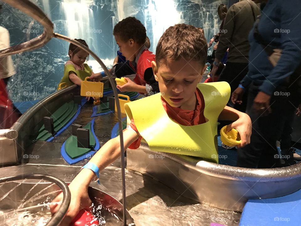 Boy playing with water exhibit at museum