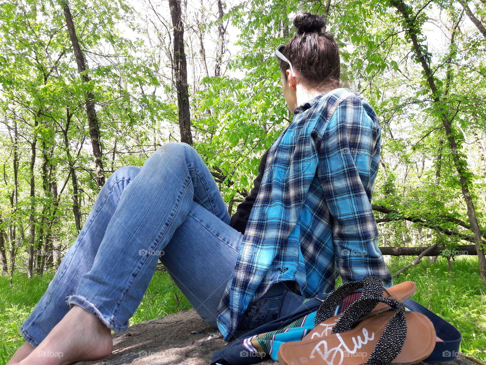 Woman sitting in the forest looking trees