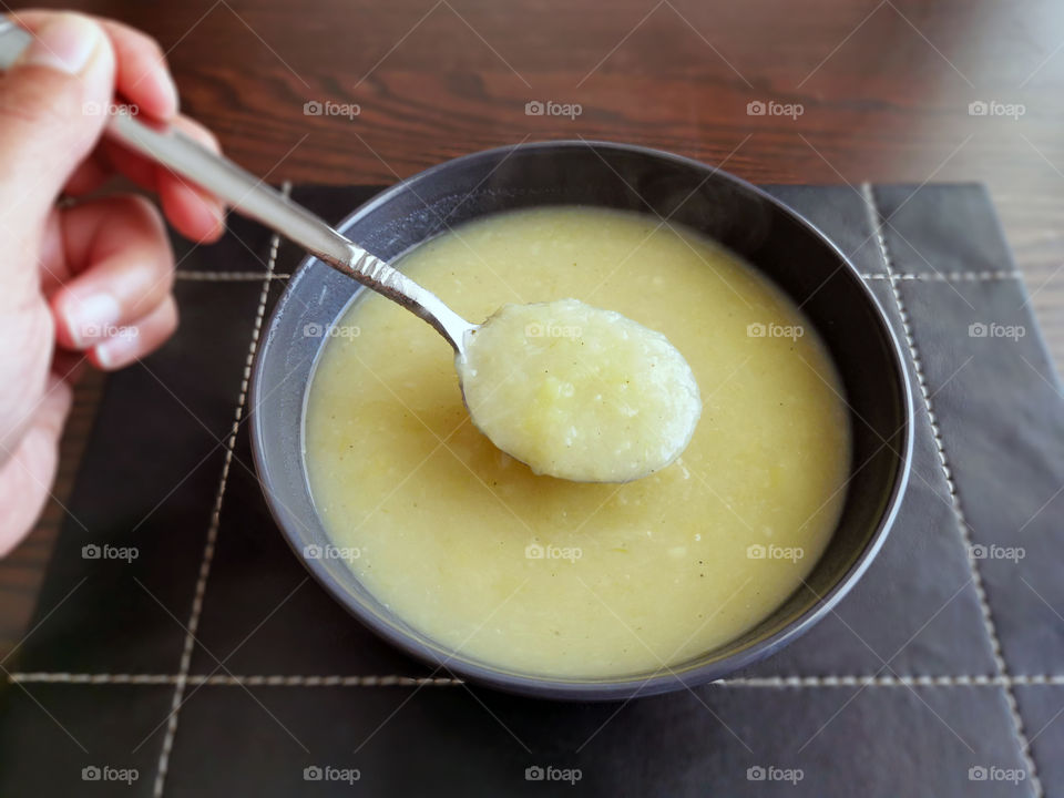 Leek and potato soup.  Selective focus on the soup in the spoon.