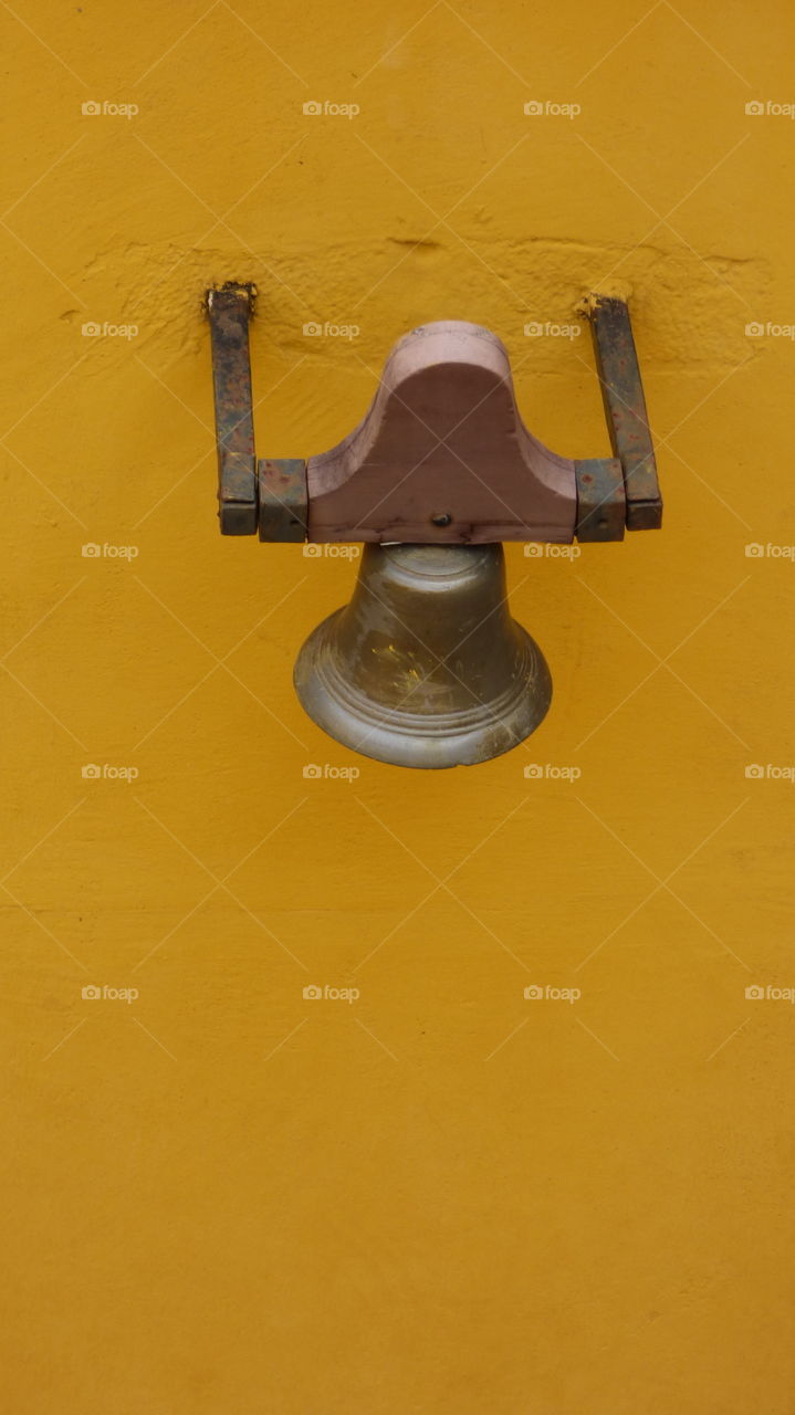 Bell on a yellow wall