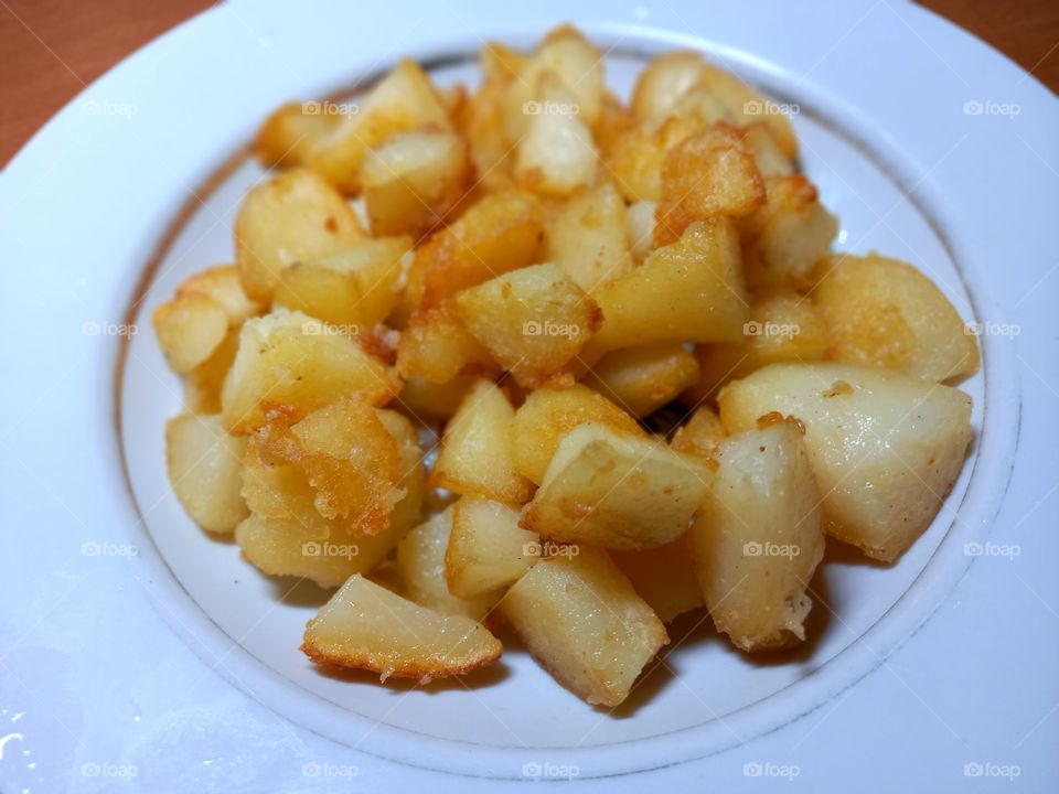 fried potatoes on a white plate